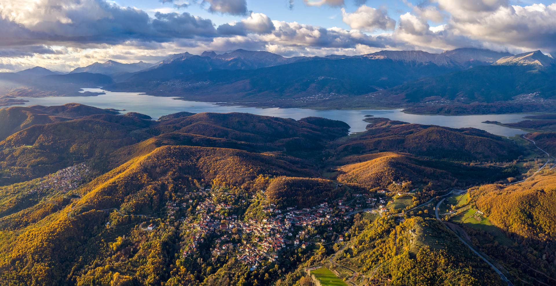Aerial view of a village above Lake Plastiras with the Agrafa mountains behind