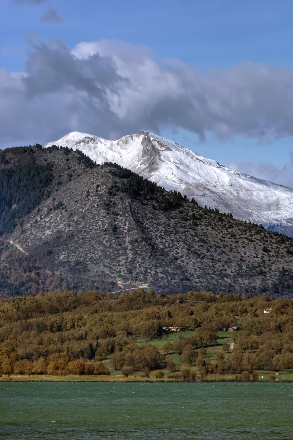 Snow on the Agrafa peaks above the lake shore